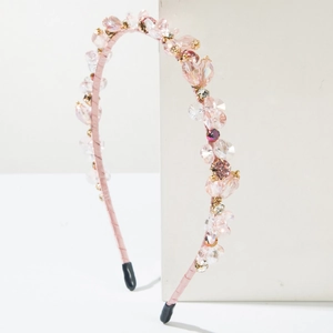 Elegant pink crystal beaded headband with gold accents on a clean white background