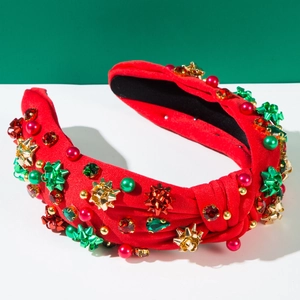 Dettaglio di una fascia per capelli rossa a nodo con strass colorati e perle festose