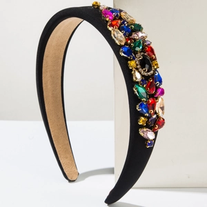 Détail de gemmes en cristal coloré cousues sur un serre-tête en satin noir chic