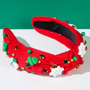 Détail d'un serre-tête de Noël rouge avec motifs Père Noël, perles et pierres précieuses