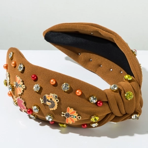 Détail du serre-tête en tricot marron avec feuilles d'érable en strass et breloques dinde