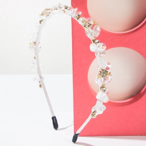 Detail of beaded headband with crystals and pearls on a white satin wrapped frame