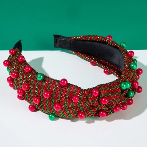 Dettaglio macro del cerchietto natalizio a righe con glitter lucidi e perle rosse e verdi