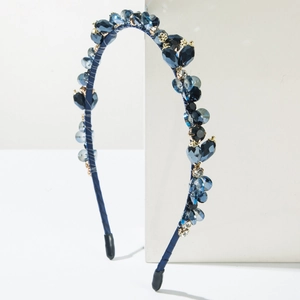 Detailed shot of sparkling blue crystal beads and golden studs on a slim headband