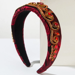 Close-up of red jacquard sponge headband with baroque gold metal rim and crystals