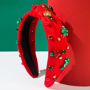 Dettaglio del cerchietto natalizio rosso con perle colorate, strass e fiocchi in metallo