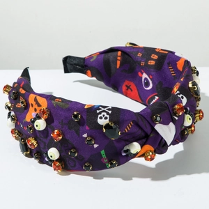 Detail of purple Halloween headband with spooky prints, crystals and eyeball 3D accents