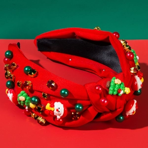 Dettaglio del cerchietto natalizio con Babbo Natale, perle e strass su tessuto rosso
