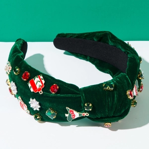 Dettaglio di un cerchietto natalizio in velluto verde con piccoli regali e decori