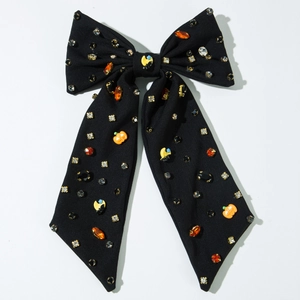 Détail du nœud noir d'Halloween orné de strass et de petits charms de citrouille