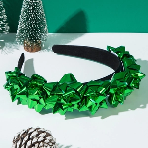 Dettaglio di fiocchi decorativi verdi lucidi su un cerchietto natalizio in tessuto nero