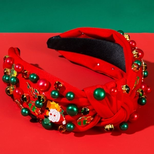 Close-up of Christmas headband with Santa charms, pearls, and rhinestones on red fabric