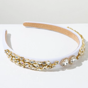 Détail de strass en cristal avec serti griffes doré sur un serre-tête blanc