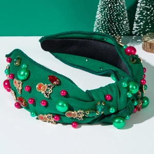 Close-up of green Christmas headband with pearls, rhinestones and festive metal charms