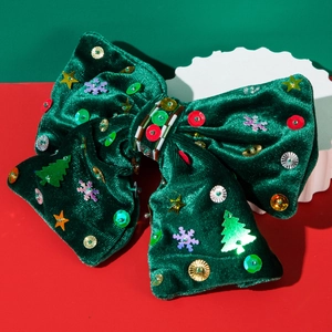 Détail d'un nœud de Noël en velours vert foncé avec sequins cousus main et étoiles
