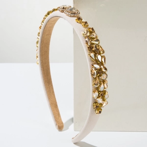 Détail d'un serre-tête vintage orné de cristaux ambrés et de strass de couleur champagne