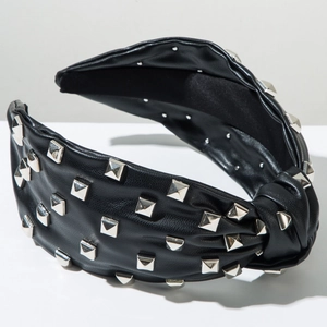 Detail of black leather headband with silver pyramid studs and stylish knot design