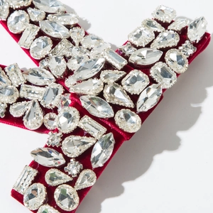 Close-up of red velvet bow hair clip with sparkling rhinestones and crystal details