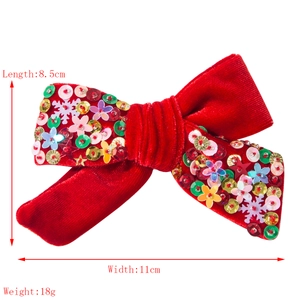 Fermaglio natalizio in velluto rosso con fiocchi di neve glitterati e cristalli su fondo bianco