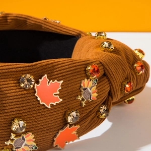 Vue macro d'un bandeau en velours côtelé marron avec feuille d'érable et strass