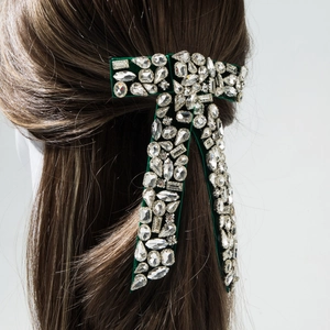 Macro view of luxurious emerald velvet bow hair clip with sparkling rhinestones details