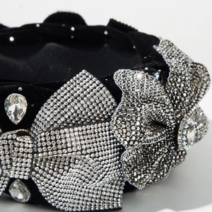 Macro shot of luxury black velvet headband with sparkling rhinestones and crystal bow detail