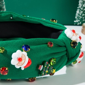 Detail of green knotted headband with Santa Claus motif and colorful rhinestones