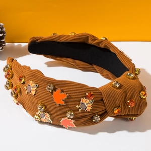 Détail d'un serre-tête en velours côtelé marron avec motifs de dinde et feuille d'érable