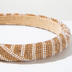 Detailed view of padded headband featuring striped patterns of white pearls and golden crystals