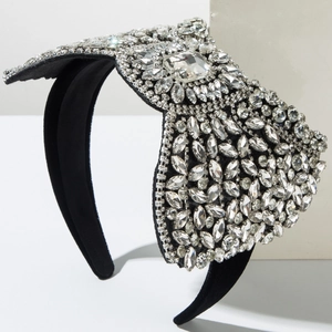 Detail of luxury bow headband with shimmering rhinestones and crystal accents on black velvet