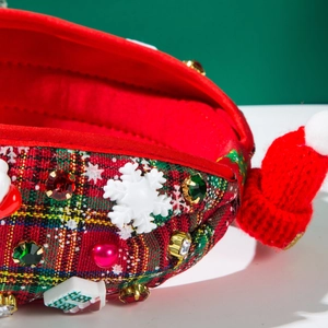Close-up of Christmas headband with red plaid fabric, rhinestones, and small Santa hat