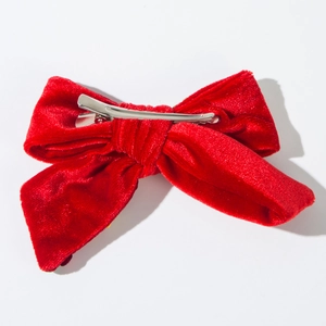Dettaglio di un fermaglio per capelli in velluto rosso con molletta a becco in metallo