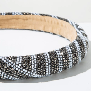 Macro detail of padded headband with rhinestones and white pearls on velvet lining