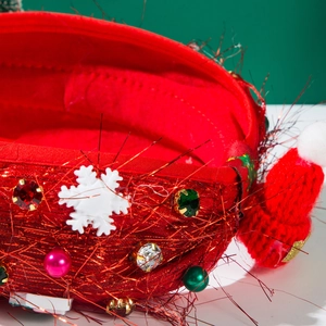 Detailed view of red tinsel fabric Christmas headband with faux gemstones and mini hat