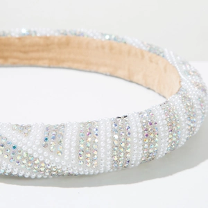 Close-up of pearl and rainbow rhinestone striped headband with beige velvet lining