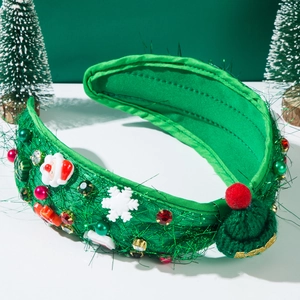 Close-up of Christmas headband with Santa, emerald fabric, and festive jewel embellishments