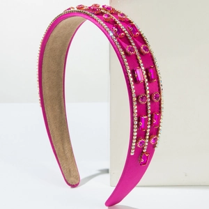 Detailed macro view of wide pink satin headband with inlaid rhinestones and gems