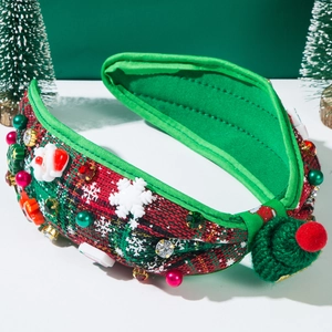 Detail of red plaid Christmas headband with Santa motifs, pearls, and a green mini hat