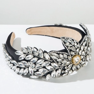Détail de cristaux cousus main et strass dorés sur un serre-tête en satin noir élégant
