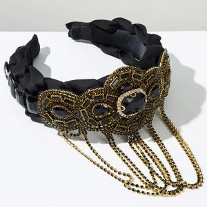 Dettaglio cerchietto in raso nero con grandi gemme nere e nappe pendenti in strass dorati