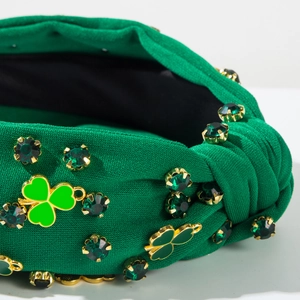 Détail macro du serre-tête de la Saint-Patrick avec strass et breloques trèfle