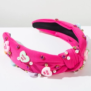 Détail du serre-tête rose noué avec breloques cœur HUG ME, perles et strass