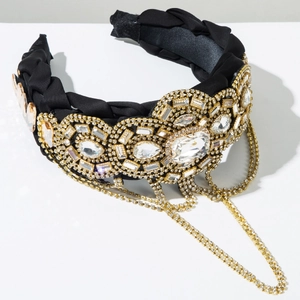 Dettaglio del cerchietto intrecciato a mano con strass di lusso e nappine a catena oro