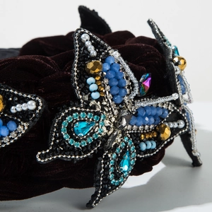 Macro view of velvet headband showing intricate blue bead and crystal butterfly detail