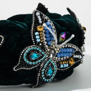 Detailed macro view of handmade crystal butterfly on a lush velvet braided headband