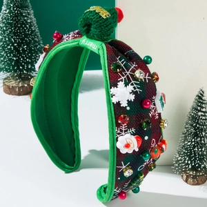Close-up of festive plaid headband with 3D Santa decor and green knit ball detail