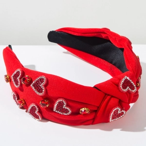 Détail du serre-tête rouge noué avec cœurs en strass étincelants et accents de pierres