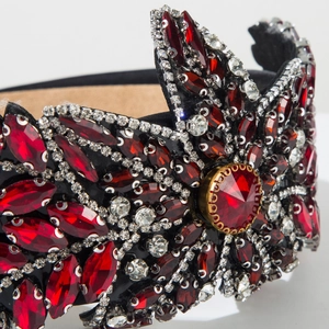 Détail de pierres marquises rouges et strass sur un serre-tête de luxe en velours