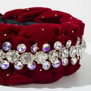 Dettaglio macro del cerchietto in velluto intrecciato bordeaux con strass e cristalli lucidi