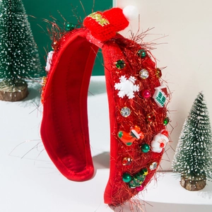 Close-up of red festive Christmas headband with a mini Santa hat and holiday decorations